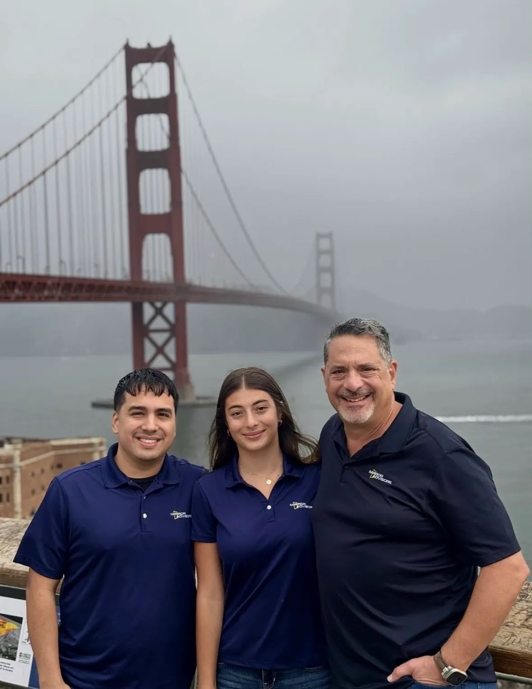 Three members of the Mirror Advisors team in front of the Golden Gate Bridge
